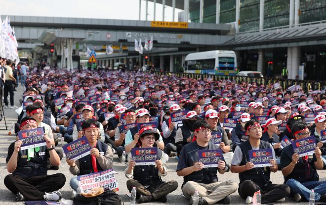 전국공항노동자연대 관계자들이 1일 서울 김포공항 국내선 3번출구에서 열린 ‘10.1 전국공항노동자 총파업대회’에서 손팻말을 흔들고 있다. 뉴시스
