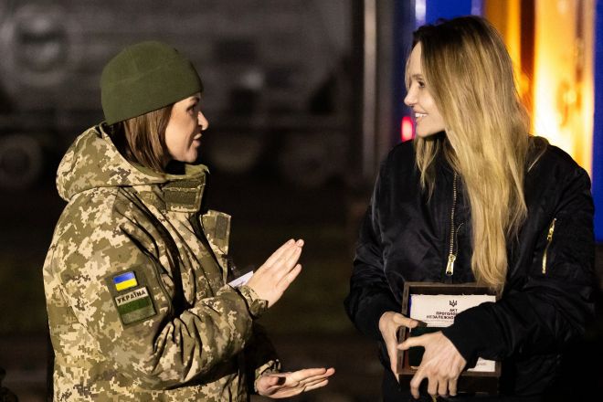 할리우드 배우 앤젤리나 졸리가 7일(현지시간) 우크라이나 헤르손과 미콜라이우 방문을 마치고 폴란드 접경지역에서 떠날 채비를 하며 우크라이나 국경 경비대원과 이야기를 나누고 있다. 2025.11.7 AFP 연합뉴스