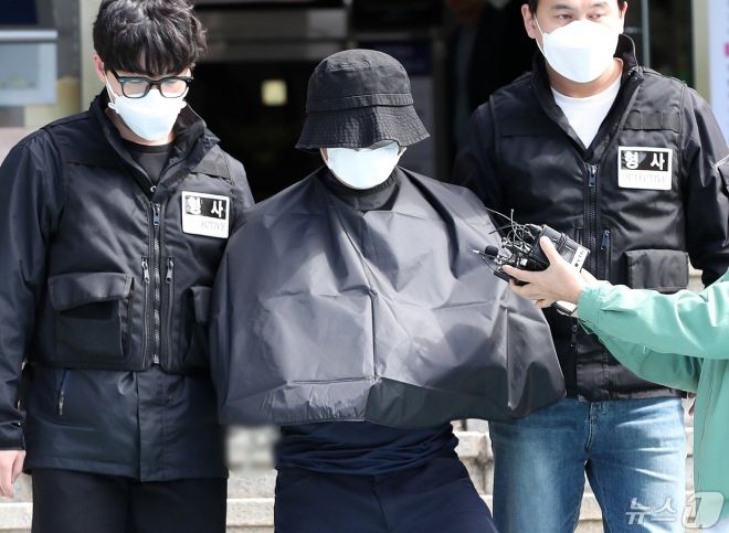 홍씨가 부산 연제경찰서에서 검찰로 송치되고 있다. 검은 가운은 국가인권위원회 권고로 인권보호를 위해 경찰이 제작했다고 한다.   뉴스1