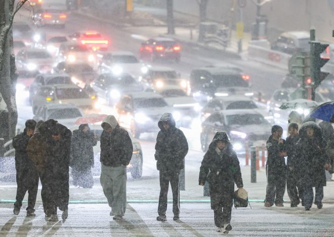 첫눈 쏟아진 서울 ‘대설 재난문자’ …  오늘 출근길 빙판 주의 - 4일 오후 서울 중구에 눈이 내리는 가운데 퇴근길 시민들이 몸을 웅크린 채 발걸음을 재촉하고 있다. 이날 첫눈이 내린 서울 전역과 수도권 등은 대설주의보가 발효됐다. 기상청은 서울과 경기 곳곳에 ‘시간당 5㎝ 이상 눈이 쏟아져 교통에 불편이 초래될 수 있다’는 내용의 ‘대설 재난문자’를 처음 발송했다. 5일 아침 최저기온은 영하 11도에서 영상 2도로, 쌓인 눈이 얼어붙을 것으로 예상됨에 따라 출근길 각별한 주의가 요구된다. 뉴시스