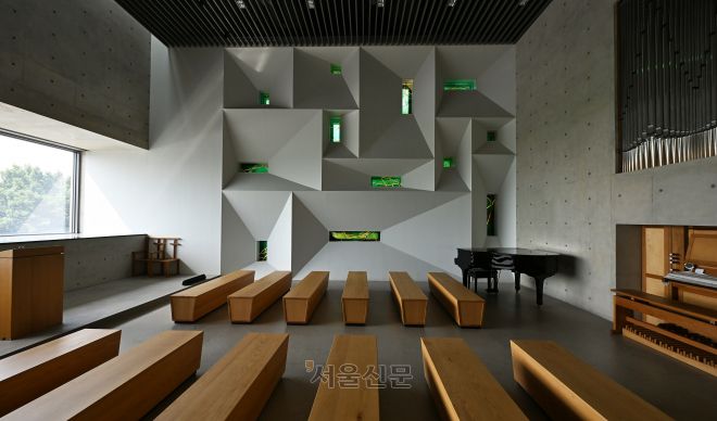 인천 강화 ‘멍때림 채플’의 예배당 모습. 벽면이 열두 제자를 상징하는 열두 개 스테인드글라스로 장식됐다. 왼쪽 통창으로는 강화 갯벌이 눈에 담긴다.