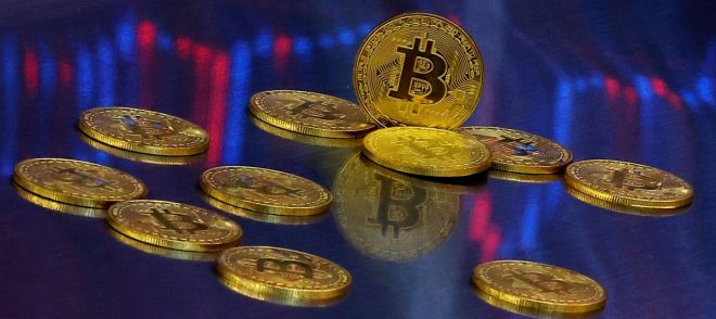 비트코인 모형이 놓인 바닥에 코인 시세 그래프가 비치는 모습. 연합뉴스