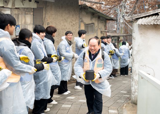 김용철(가운데) 국제라이온스협회 354-D지구 총재가 10일 서울 동작구 사당2동 정금마을 일대에서  봉사자들과 함께 연탄을 나르고 있다.  사진: 국제라이온스협회 354-D지구 제공.