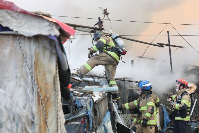 지난 16일 서울 강남구 개포동 구룡마을에서 소방관들이 잔불을 진압하고 있다. 연합뉴스