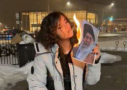 하메네이 사진을 불태워 담배에 불 붙이는 이란 여성. X 캡처