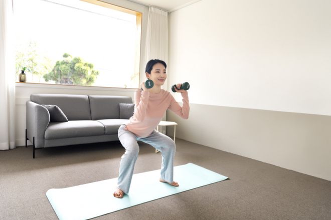 집에서 가벼운 덤벨을 들고 스쿼트 동작을 하는 모습. 연구에 따르면 무거운 중량이 아니어도 근육이 지칠 때까지 반복하면 근력 향상을 기대할 수 있다. 아이클릭아트