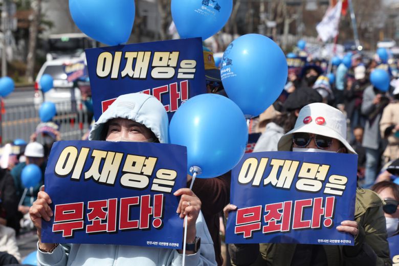 더불어민주당 이재명 대표의 공직선거법 2심 선고 공판을 앞둔 26일 서울 서초구 서울중앙지방법원 인근에서 지지자들이 손팻말을 들고 있다 / 사진=연합뉴스