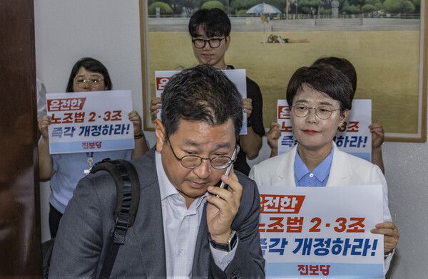 진보당 전종덕 의원이 28일 국회 환경노동위원회 법안소위가 열린 소회의실 앞에서 손팻말을 들고 여야 의원들에게 '온전한 노조법 2ㆍ3조(노란봉투법) 즉각 개정'을 촉구하고 있다. 2025.7.28