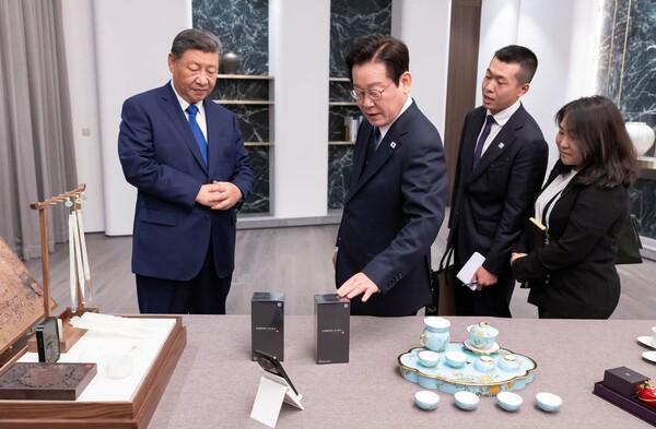 이재명 대통령과 시진핑 중국 국가주석이 1일 경북 소노캄 호텔에서 국빈만찬 전 갖은 친교 시간을 갖고 있다. 이날 이 대통령은 시 주석에게 본비자나무로 제작된 바둑판과 조각 받침대, 나전칠기 자개원형쟁반을 선물했고, 시 주석은 이 대통령에게 중국 브랜드인 샤오미 스마트폰과 문방사우 세트를 선물했다. 대통령실 제공. 연합뉴스