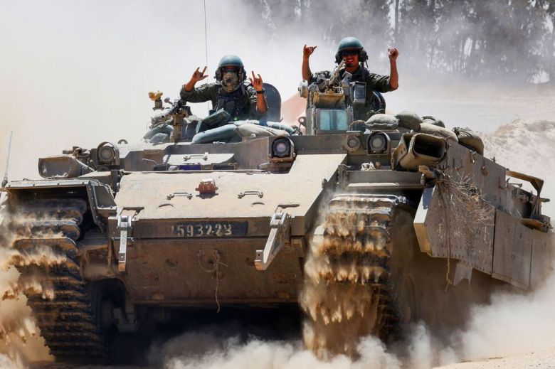 2025년 5월20일 팔레스타인 땅 가자지구로 진입하는 이스라엘군 병사들이 전차 위에서 팔을 들어 보이고 있다. AFP 연합뉴스