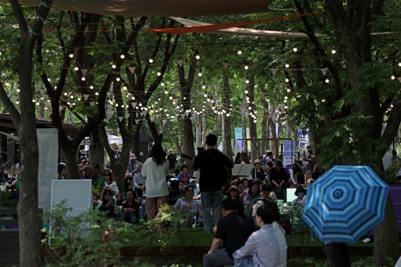 숲속무대에서는 ‘정원작은음악회’가 열려 관람객들이 노래를 감상하고 있다.