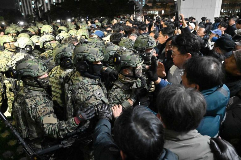 2024년 12월3일 대한민국 대통령 윤석열이 계엄령을 선포한 이튿날인 4일 새벽 군인들이 서울 국회의사당에 진입하려 하고 있다. 윤석열 대한민국 대통령은 “반국가 세력”이라고 비난하며 북한의 위협으로부터 국가를 지키겠다며 계엄령을 선포했다. AFP연합뉴스