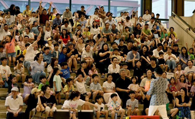 7월4일 저녁 서울 종로구 서울역사박물관에서 열린 ‘일루션 매직쇼’에서 문준호 마술사(뒷모습)가 200여 명의 학부모와 아이들과 함께 마술쇼를 진행하고 있다.