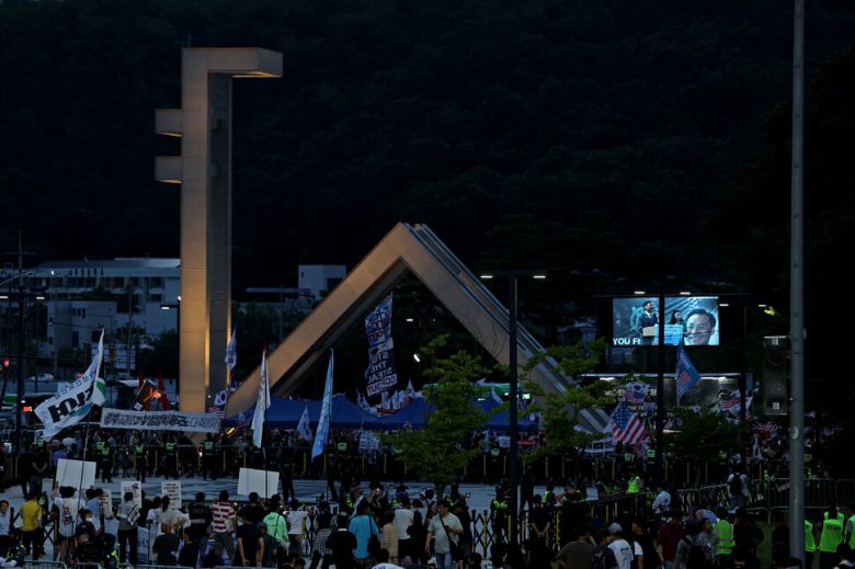 ‘샤’ 자 형태의 서울대 정문에 불을 밝힌 채 ‘사기꾼 모스 탄 방한 반대 대학생 긴급행동’(아래쪽)이 교문 앞에서 특강을 하는 탄 교수를 규탄하고 있다.