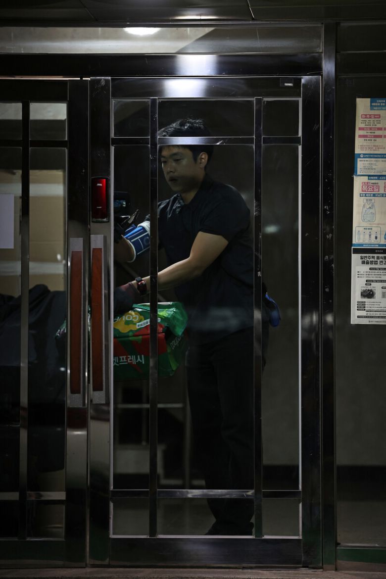 2025년 11월13일 서울 송파구에서 류석우 기자가 한 다세대주택에서 회수한 프레시백을 들고나오고 있다. 이 주택의 공동현관문 외부 센서등은 반응이 늦어, 건물 안으로 들어갈 때 문턱 등이 잘 보이지 않았다. 이종근 선임기자 root2@hani.co.kr