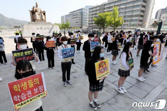 (서울=뉴스1) 이광호 기자 = 서울실용음악고등학교 학생들이 6일 오전 서울 광화문광장에서 학교 정상화 촉구 및 학생 법적조치 협박에 대한 이사회 규탄 기자회견을 하고 있다. 학생들은 기자회견에서 학교장의 비도덕적이고 독단적인 행태와 학교 설립자는 학교의 연습장을 개인 목적으로 무단 사용하며 학생들의 학습권을 침해하고 있다고 주장했다. 또한 주차장에서 배식을 하는 등 급식실도 보장받지 못하고 있다고 설명했다. 서울실용음악고등학교는 지난해 8월 개교 이후 첫 서울시교육청 감사에서 설립자이자 전 교장이 가족을 동원해 학생들이 지급한 수업료 20여억원을 부당 사용하고 회계 장부를 조작한 정황이 드러났다. 설립자 일가는 감사 결과에 불복해 교육청을 상대로 행정소송을 진행 중이다.2020.5.6/뉴스1