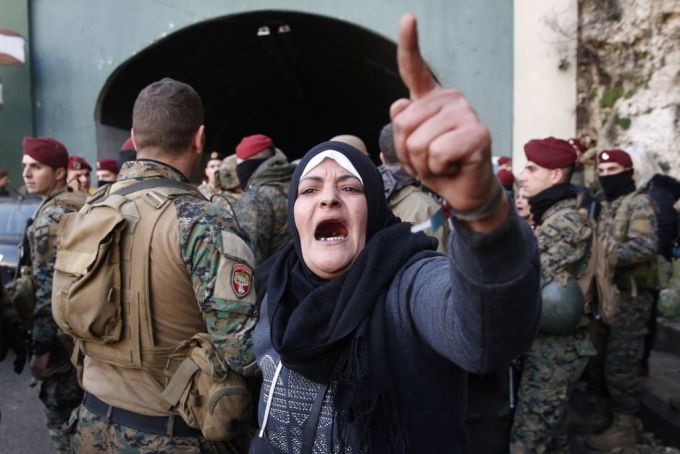 [베이루트=AP/뉴시스] 지난 1월 3일(현지시간)  레바논 베이루트 북부 나흐르 엘 칼브 마을에서 레베논 병사들이 베이루트와  레바논 북부를 연결하는 주요 고속도로를 막고 시위를 벌이던 시위대를 해산한 후 도로를 개통하는 가운데 한 반정부 시위 여성이 구호를 외치고 있다. 2020.01.03.