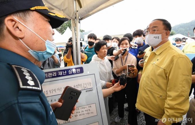 [서울=뉴시스]홍남기 부총리 겸 기획재정부 장관이 7일 장미피해 관련 강원도 춘천 의암댐을 방문, 집중호우로 인한 보트 침몰 사고 현장에서 관계자로부터 상황설명을 듣고 있다. (사진=기획재정부 제공) 2020.08.07   photo@newsis.com