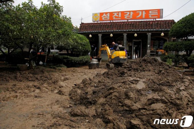 (순천=뉴스1) = 12일 오전 섬진강이 범람하며 침수피해를 입은 전남 순천시 황전면의 식당 마당에 중장비가 들어가 진흙은 걷어내고 있다. 이 지역은 구례와 섬진강을 사이에 두고 순천행정구역인 지역으로 약 4킬로미터의 강변을 따라 40여 상가와 주택이 자리하고 있고 , 대부분 홍수피해를 입었다.2020.8.12/뉴스1