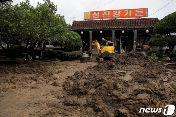 (순천=뉴스1) = 12일 오전 섬진강이 범람하며 침수피해를 입은 전남 순천시 황전면의 식당 마당에 중장비가 들어가 진흙은 걷어내고 있다. 이 지역은 구례와 섬진강을 사이에 두고 순천행정구역인 지역으로 약 4킬로미터의 강변을 따라 40여 상가와 주택이 자리하고 있고 , 대부분 홍수피해를 입었다.2020.8.12/뉴스1