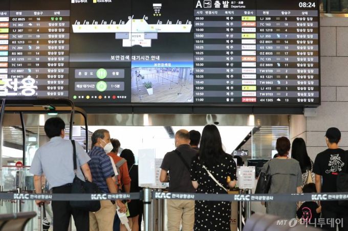 [서울=뉴시스] 전진환 기자 = 본격적인 휴가철을 맞아 27일 오전 서울 강서구 김포공항 국내선 청사에서 코로나19로 해외 대신 국내여행을 떠나는 여행객들이 탑승장으로 가기 위해 줄을 서고 있다. 2020.07.27.    amin2@newsis.com