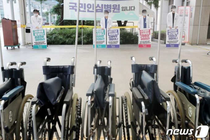 의과대학 정원 확대 등 정부의 의료정책에 반대하는 인턴·레지던트 등 전공의들이 순차적 집단휴진에 들어간 21일 오후 경기도 수원시 아주대학교 병원에서 의료진들이 피켓을 들고 서 있다. /사진=뉴스1
