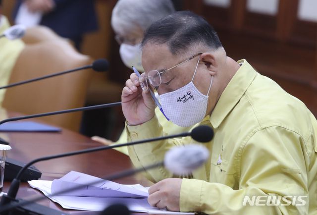 홍남기 경제부총리 겸 기획재정부 장관이 이달 21일 오전 서울 종로구 정부서울청사 영상회의실에서 열린 코로나19 대응 중앙재난안전대책본부(중대본) 회의에 참석해 자료를 살펴보고 있다. / 사진제공=뉴시스