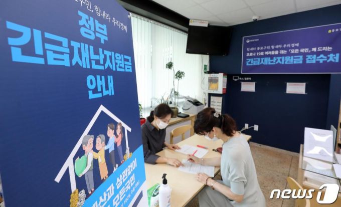 (서울=뉴스1) 김진환 기자 = 24일 오전 서울 종로구 삼청동 주민센터에서 한 시민이 신종 코로나바이러스 감염증(코로나19) 관련 정부 긴급재난지원금 신청을 하고 있다.   행정안전부에 따르면 정부 긴급재난지원금 신청은 이날 마감된다. 사용은 31일까지 가능하며 이때까지 다 못 쓴 잔액은 국가 및 지방자치단체로 환수한다. 2020.8.24/뉴스1