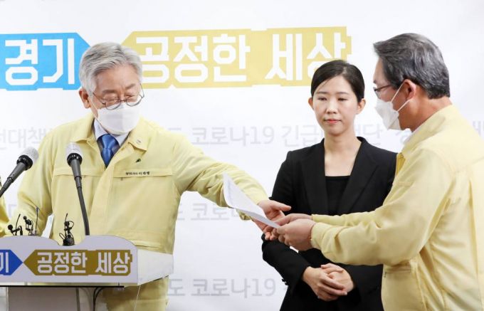 이재명 경기도지사가 지난달 20일 오전 경기도 수원시 팔달구 경기도청에서 신종 코로나바이러스 감염증(코로나19) 수도권 대유행에 따른 대도민 긴급호소 기자회견 중 김희겸 행정1부지사로부터 사랑제일교회 관련 자료를 전달받고 있다. / 사진제공=뉴시스