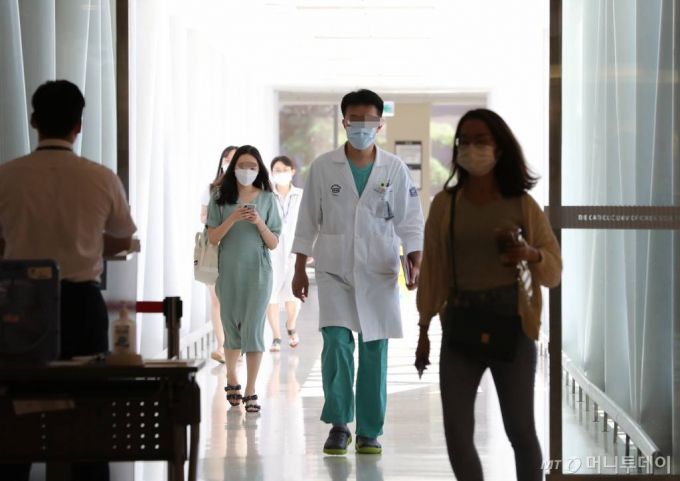[서울=뉴시스] 전진환 기자 = 박능후 보건복지부장관과 최대집 대한의사협회장이 의대 정원 증원, 공공의대 신설 등과 관련한 합의안에 서명한 4일 오후 서울 서초구 서울성모병원에서 가운을 입은 병원 관계자들이 의대와 연결된 통로를 걷고 있다. 2020.09.04.  amin2@newsis.com
