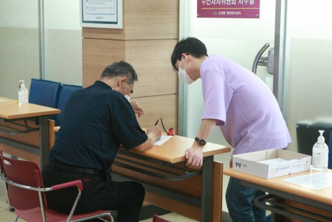 [강원 춘천시가 긴급재난지원금 오프라인 신청 접수를 개시한 14일 오후 소양동 행정복지센터에서 직원이 재난지원금 신청자에게 신청서 작성 안내를 하고 있다. /사진=뉴시스