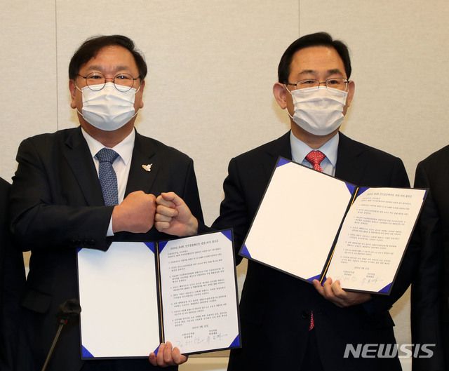 김태년 더불어민주당 원내대표와 주호영 국민의힘 원내대표가 22일 서울 여의도 국회에서 2020년도 제4차 추가경정예산안 합의사항 발표에서 합의문에 서명한 후 합의문을 들고 기념촬영을 하고 있다. / 사진제공=뉴시스