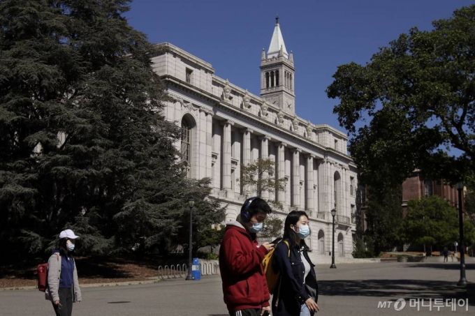 [버클리=AP/뉴시스 미국 캘리포니아 버클리대(UC버클리) 캠퍼스에서 3월 11일 학생 몇몇이 마스크를 쓴 채 코로나 19로 텅빈 교정을 걷고 있다. 2020.05.22.