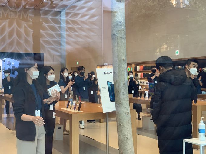 애플 가로수길 직원들이 '아이폰12' 구매를 축하하고 있다. /사진=박효주