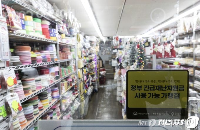 국내 신종 코로나바이러스 감염증(코로나19) 일일 신규 확진자가 500명을 넘으며 3차 대유행이 현실화되는 가운데 26일 서울 중구 남대문시장의 한 상가에 긴급재난지원금 사용 가능 안내문이 붙어있다. /사진=뉴스1