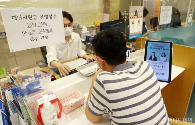 정부 긴급재난지원금 현장 신청 첫 날인 지난 5월 18일 오전 서울 중구 우리은행 을지로지점에서 시민들이 상담을 받고 있다. / 사진=김휘선 기자 hwijpg@