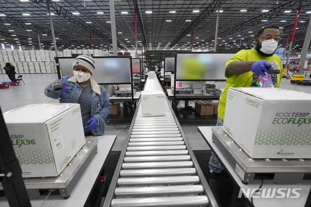 [올리브브랜치=AP/뉴시스]20일(현지시간) 미 미시시피주 올리브 브랜치의 메케슨 물류센터에서 이곳 직원들이 모더나의 코로나19 백신 배송 준비를 하고 있다. 미국에서 두 번째로 당국의 승인을 받은 모더나 백신의 배송이 시작돼 미국에서는 21일부터 모더나 백신 접종도 시작할 것으로 보인다. 2020.12.21.