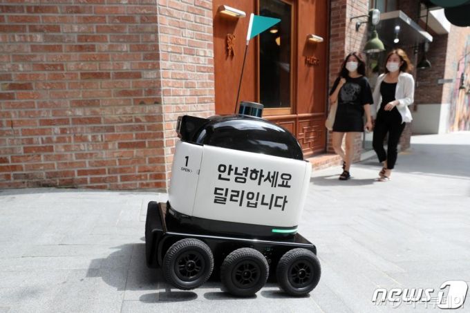 (수원=뉴스1) 조태형 기자 = 20일 오후 경기도 수원시 영통구 앨리웨이 광교에서 실외 자율주행 배달 로봇 '딜리드라이브'가 음식을 배달하고 있다.  앨리웨이 광교는 최근 신종 코로나바이러스 감염증(코로나19) 확산으로 비대면 주문·배달을 선호하는 고객들이 늘면서 배달 로봇이 식당에서 음식을 수령하여 실외 주행을 통해 야외 광장과 아파트 등 주거단지 고객에게 전달하는 서비스를 도입했다. 2020.8.20/뉴스1