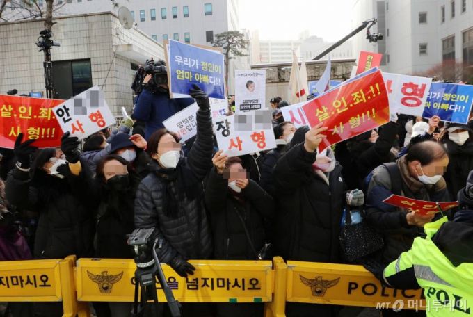 학대 받아 숨진 것으로 알려진 정인이 양부모에 대한 첫 재판이 열린 13일 오전 서울 양천구 서울남부지방검찰청 앞에서 양모 장씨가 탄 것으로 추정되는 호송차량을 향해 시민들이 항의하고 있다./사진=뉴시스(공동취재사진)