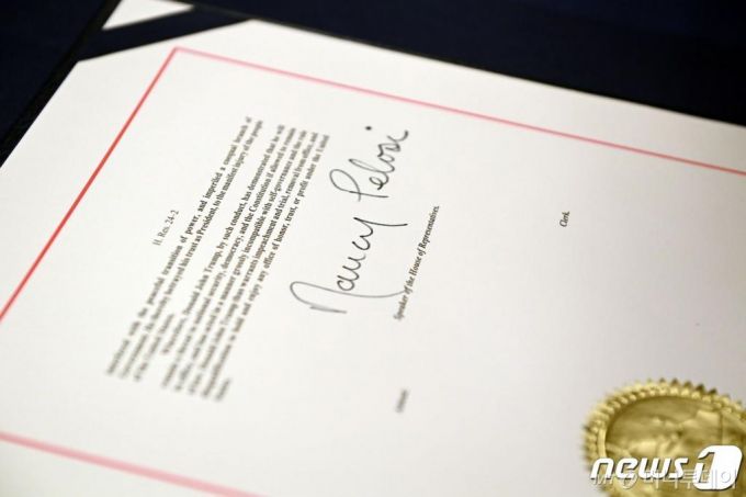 (워싱턴 AFP=뉴스1) 우동명 기자 = 13일(현지시간) 워싱턴 의사당의 하원 본회의장에서 도널드 트럼프 미국 대통령의 탄핵소추안에 낸시 펠로시 하원의장의 서명이 보인다.  ⓒ AFP=뉴스1