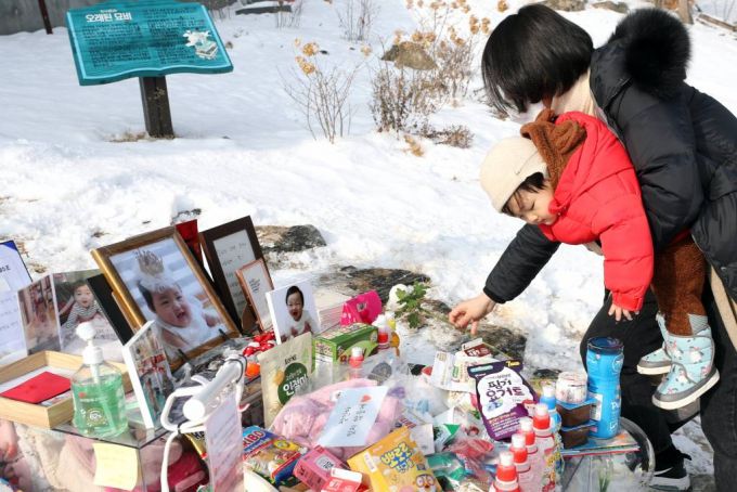 [양평=뉴시스]이윤청 기자 = 정인이 양부모에 대한 첫 재판이 열린 13일 경기도 양평군 서종면 하이패밀리 안데르센 공원묘원을 찾은 시민들이 고 정인 양을 추모하며 국화를 놓고 있다. 2021.01.13. radiohead@newsis.com