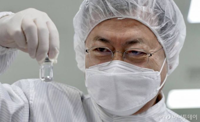 [안동=뉴시스]추상철 기자 =문재인 대통령이 20일 오전 경북 안동시 SK바이오사이언스 공장 코로나19 백신 완제 제조실에서 분류중인 백신을 들어보이고 있다. SK바이오사이언스 공장에서는 국민들의 코로나19 예방 접종을 위해 공급될 아스트라제네카 백신을 위탁생산하고 있다. 2021.01.20. scchoo@newsis.com