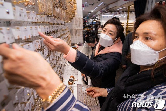 (서울=뉴스1) 국회사진취재단 = 나경원 국민의힘 서울시장 보궐선거 예비후보가 10일 오후 서울 중구 남대문 시장을 방문해 귀걸이를 구입하고 있다. 2021.2.10/뉴스1