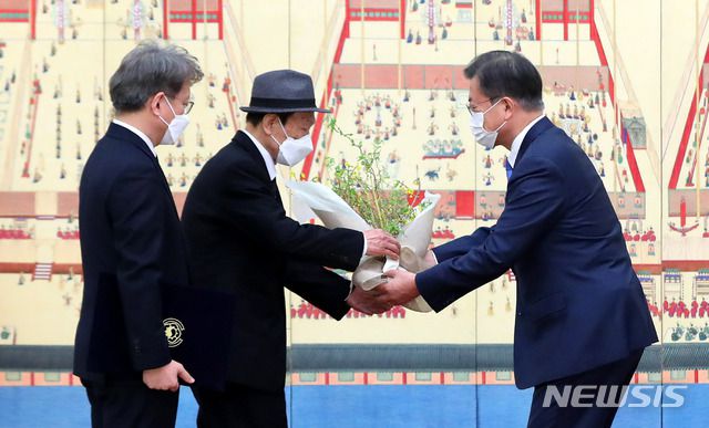 [서울=뉴시스]추상철 기자 = 문재인 대통령이 15일 오전 청와대 본관에서 권칠승 중소벤처기업부 장관 부친에게 꽃다발을 전달하고  있다. 2021.02.15. scchoo@newsis.com