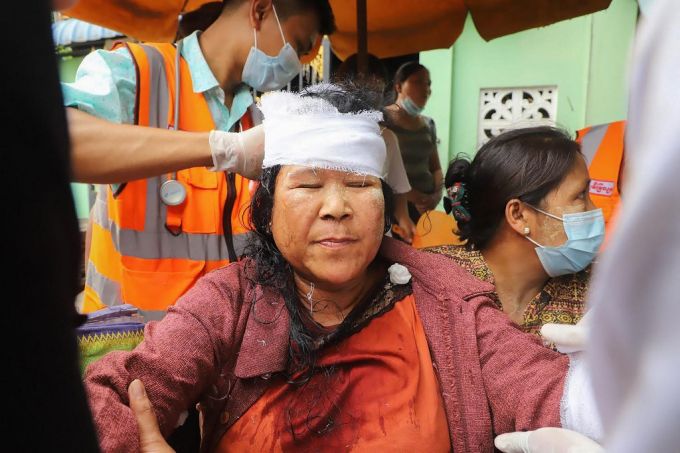 지난 20일 미얀마 만달레이에서 군부 쿠데타 반대 시위에 참여한 한 시민이 구타를 당한 뒤 머리를 싸매고 있다./사진=AFP