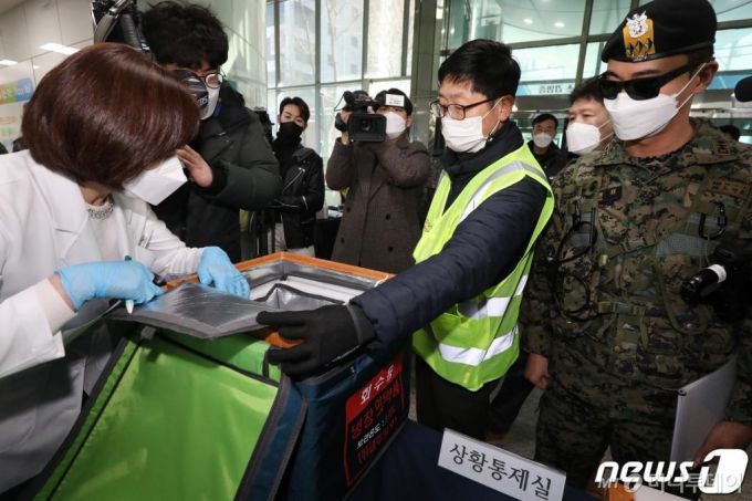 (대구=뉴스1) 공정식 기자 = 아스트라제네카 백신 수송 훈련이 실시된 19일 오후 백신 수송 차량이 군과 경찰의 경호 속에 대구 북구보건소에 도착해 보건소 상황실에서 의료진이 백신을 확인하고 있다. 2021.2.19/뉴스1