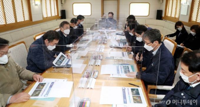 [부산=뉴시스]박영태 기자 = 문재인 대통령이 25일 부산에서 열린 ‘동남권 메가시티 구축 전략 보고’에 참석, 가덕도 공항 후보지로 이동하는 선상에서 열린 '가덕도 공항 보고 및 동남권 메가 시티 간담회'에 참석해 이병진 부산시장 권한대행으로 부터 관련보고를 받고 있다. 2021.02.25. since1999@newsis.com