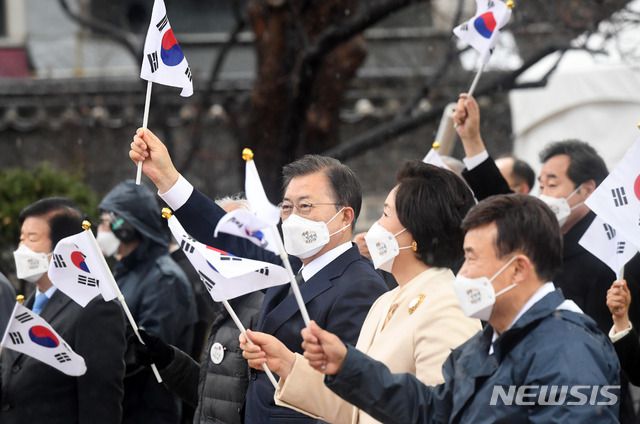 [서울=뉴시스]추상철 기자 = 문재인 대통령과 김정숙 여사가 1일 오전 서울 종로구 탑골공원에서 열린 제102주년 31절 기념식에 참석해 태극기를 흔들고 있다. 2021.03.01. scchoo@newsis.com