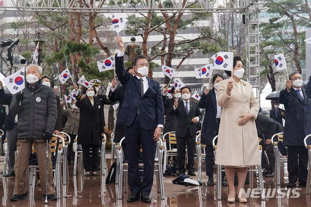 [서울=뉴시스추상철 기자 = 문재인 대통령와 김정숙 여사가 1일 오전 서울 종로구 탑골공원에서 열린 제102주년 31절 기념식에 참석해 태극기를 흔들고 있다. 2021.03.01. scchoo@newsis.com