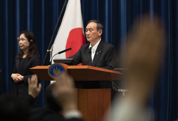 스가 요시히데 일본 총리가 7일 도쿄에서 열린 기자회견에서 발언한 뒤 취재진이 손을 들어 질문하자 잠시 멈춰 있다. /AP=뉴시스